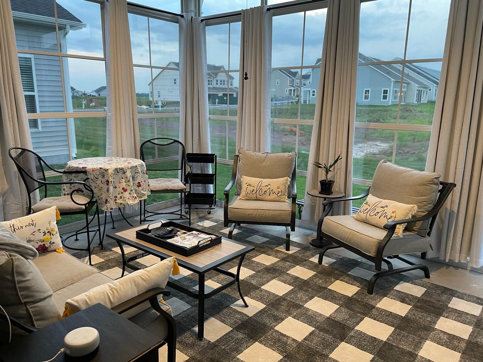 Interior of a sunroom with floor to ceiling windows.