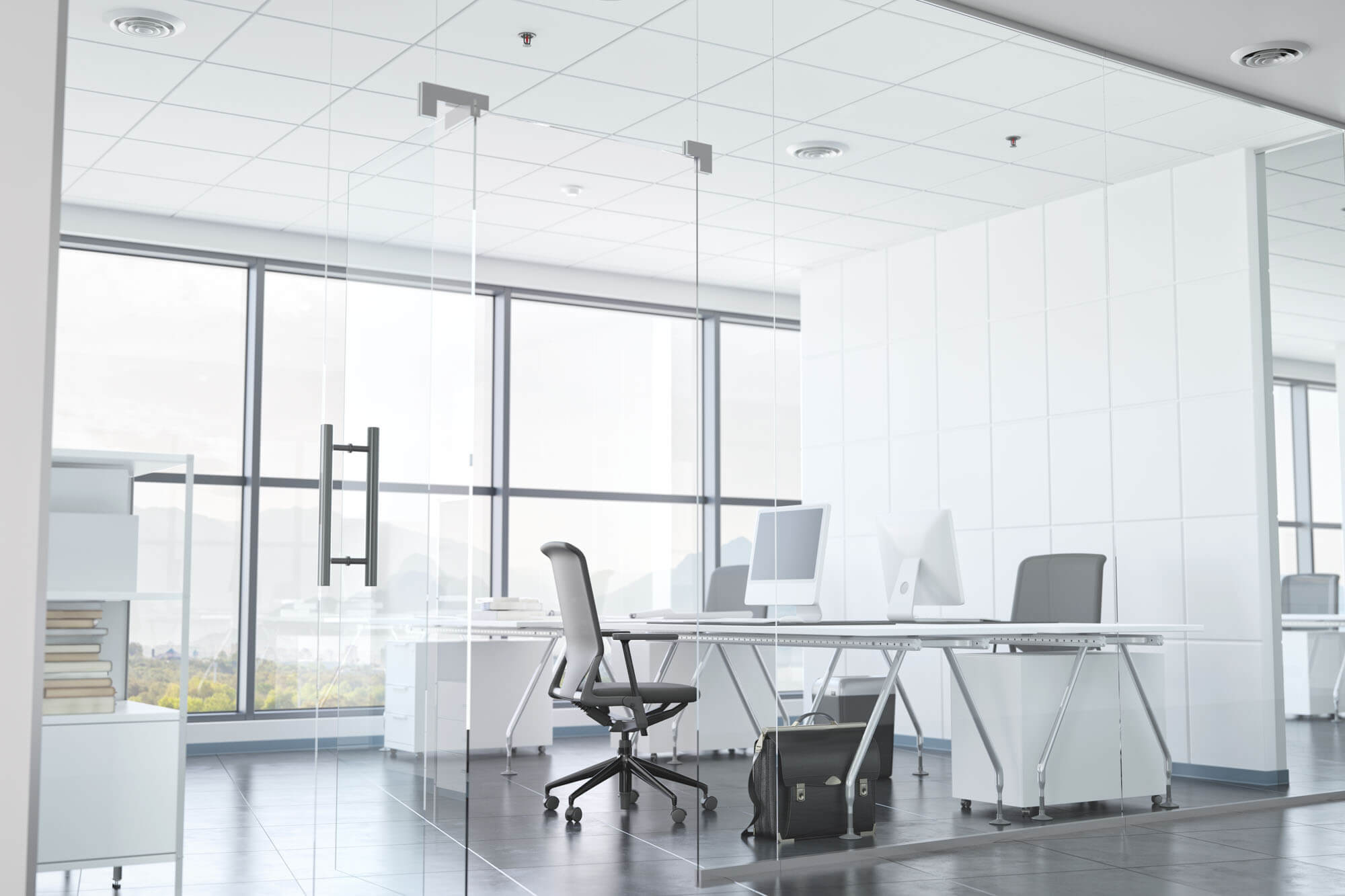 Interior of an office building with glass walls, doors, and floor to ceiling windows.